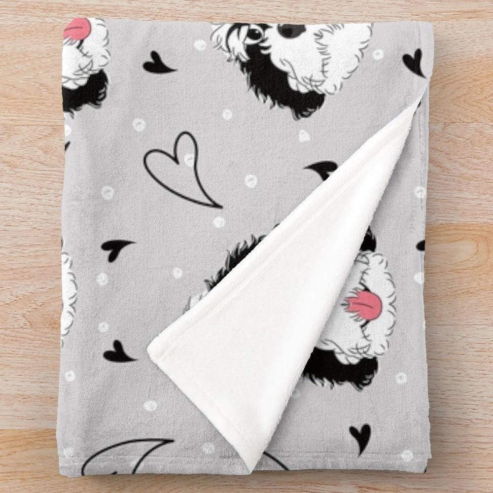 A soft, plush blanket featuring a black and white bernedoodle with a funny emoji pattern