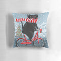 A black cat wearing a hat, riding a bicycle on a winter landscape with a Christmas tree.