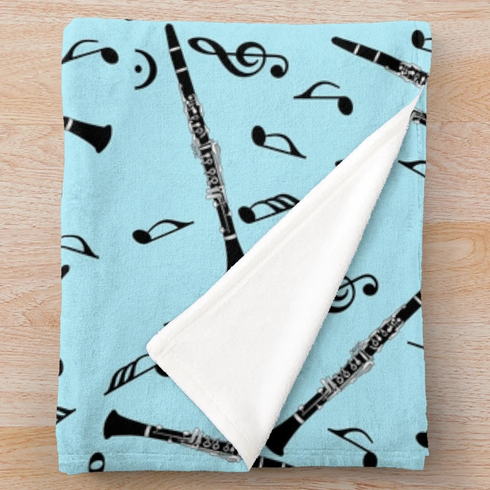 Black plush blanket with a clarinet music note pattern design