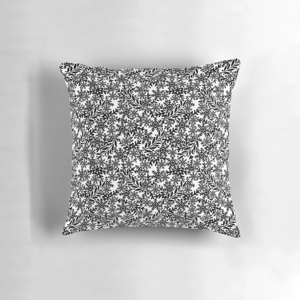A stylish black pillow with a subtle snowflake design, perfect for adding a wintry touch to your home.