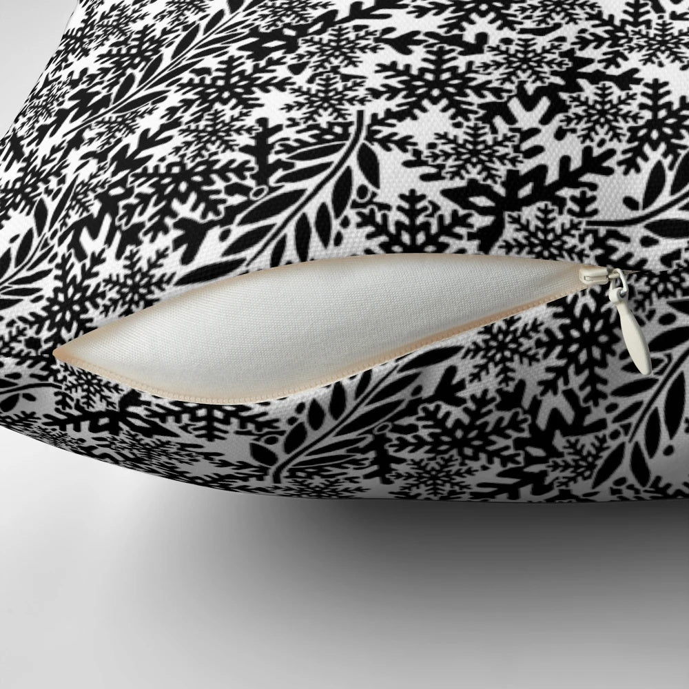 A stylish black pillow with a subtle snowflake design, perfect for adding a wintry touch to your home.