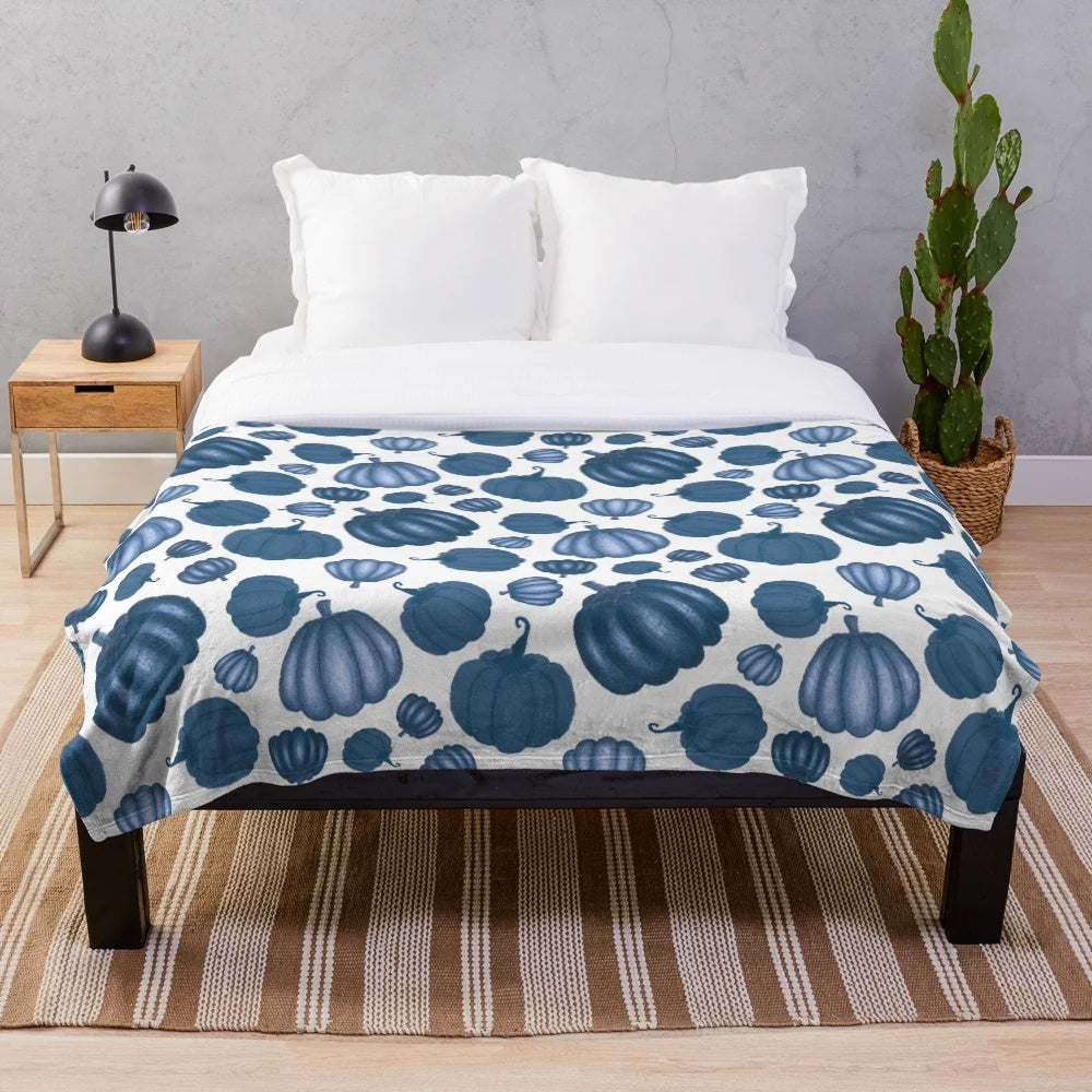 Blue pumpkin pattern on a plush white blanket