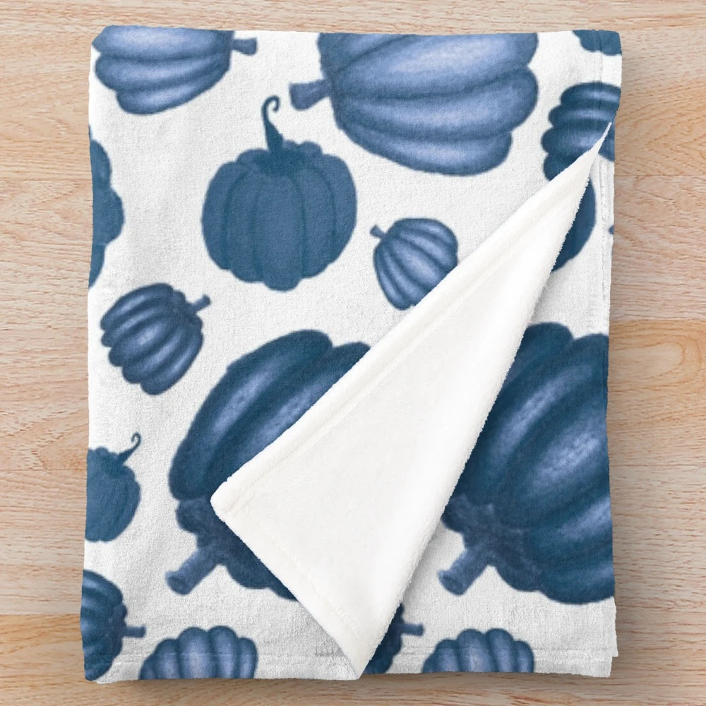 Blue pumpkin pattern on a plush white blanket