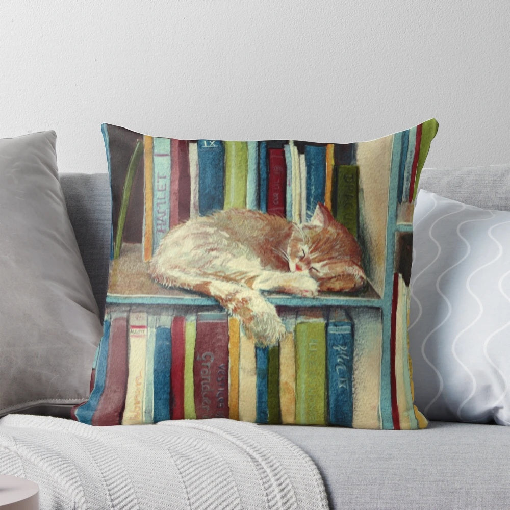 "A soft, fluffy pillow with a cute kitten illustration and books, perfect for book lovers and reading enthusiasts."