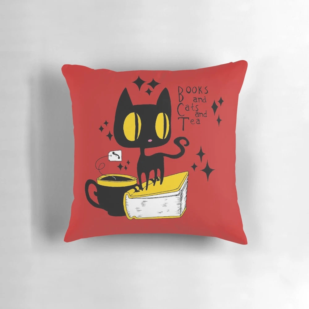 A soft, plush pillow featuring a charming illustration of books, cats, and tea in a retro, kawaii style.