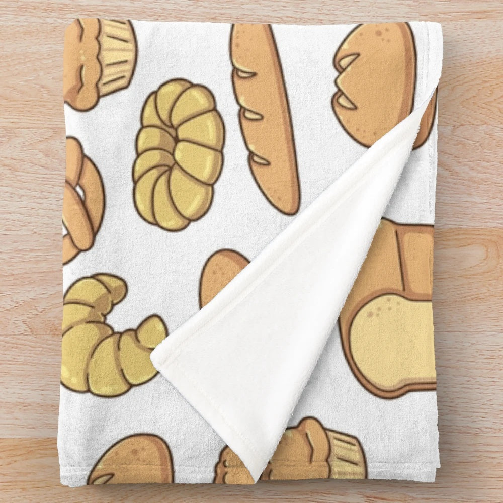 Plush blanket featuring an assortment of bread designs including baguettes, croissants, and loaves of bread