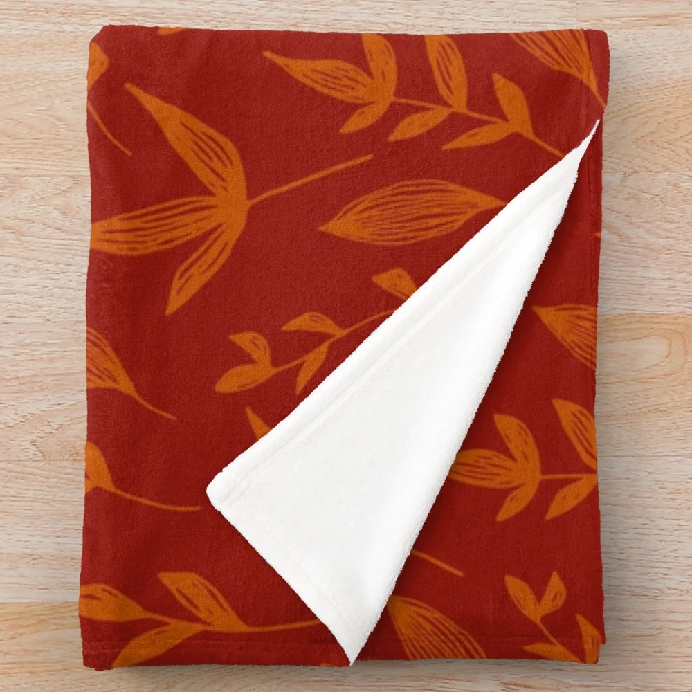 Burnt orange plush blanket with autumn leaves pattern
