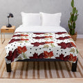 Burnt orange autumn pattern plush blanket with maple leaves detail