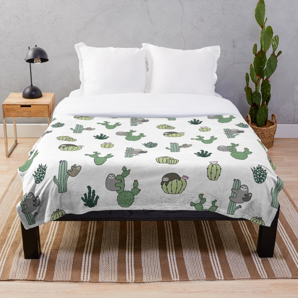 Cozy plush blanket featuring a repeating pattern of sloths and cacti in green and white