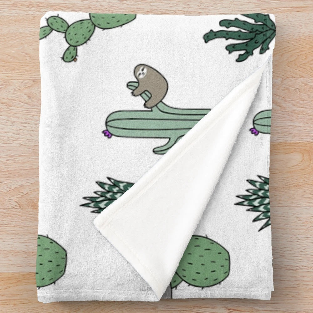 Cozy plush blanket featuring a repeating pattern of sloths and cacti in green and white