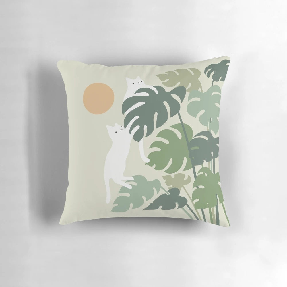 A cozy pillow featuring a cat resting next to a lush, green plant in a nature-inspired setting