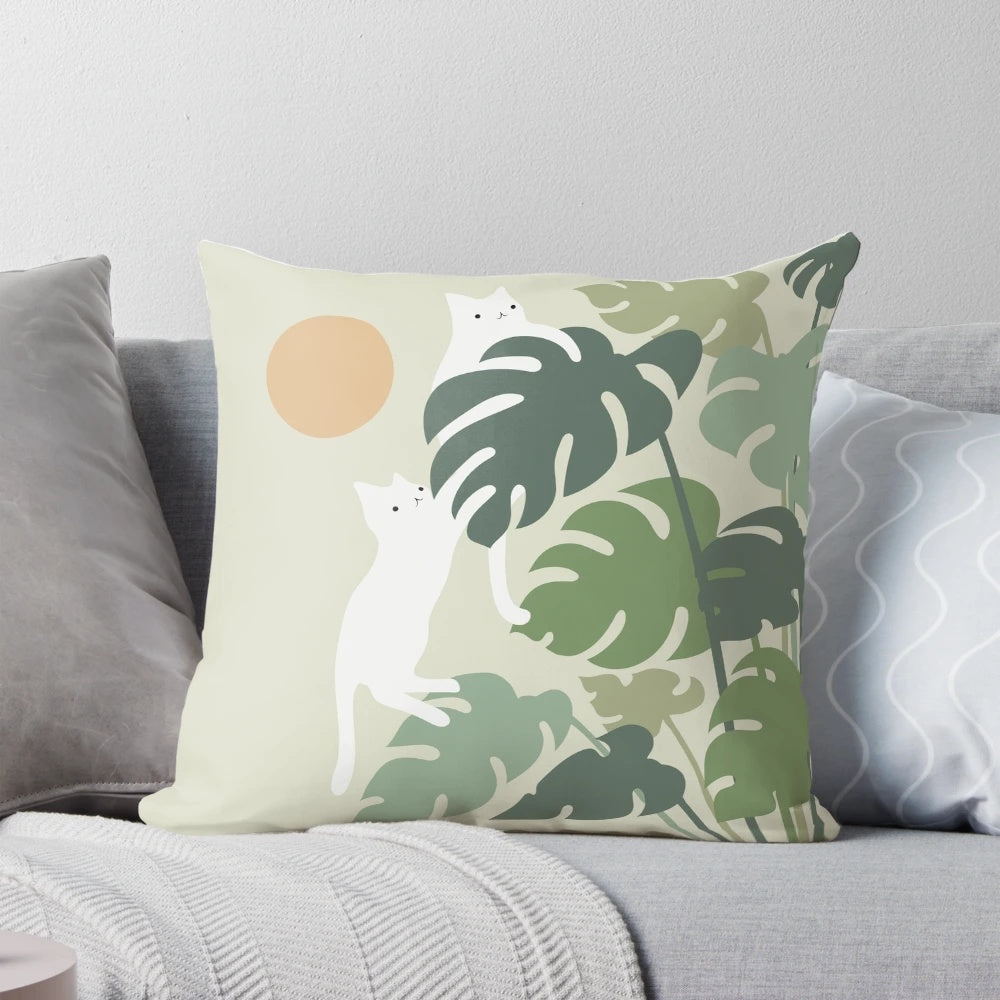 A cozy pillow featuring a cat resting next to a lush, green plant in a nature-inspired setting