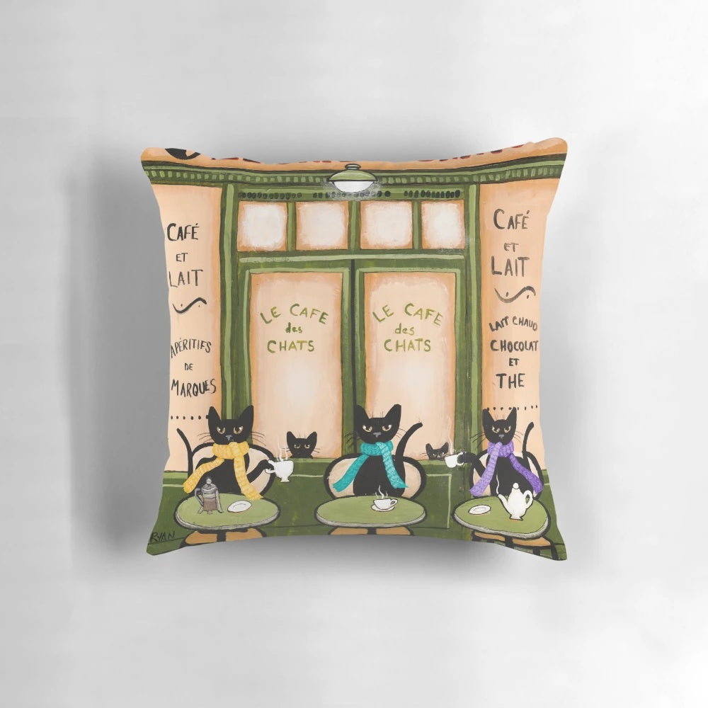 Whimsical black cat pillow featuring a cozy café scene, perfect for cat lovers and coffee enthusiasts.