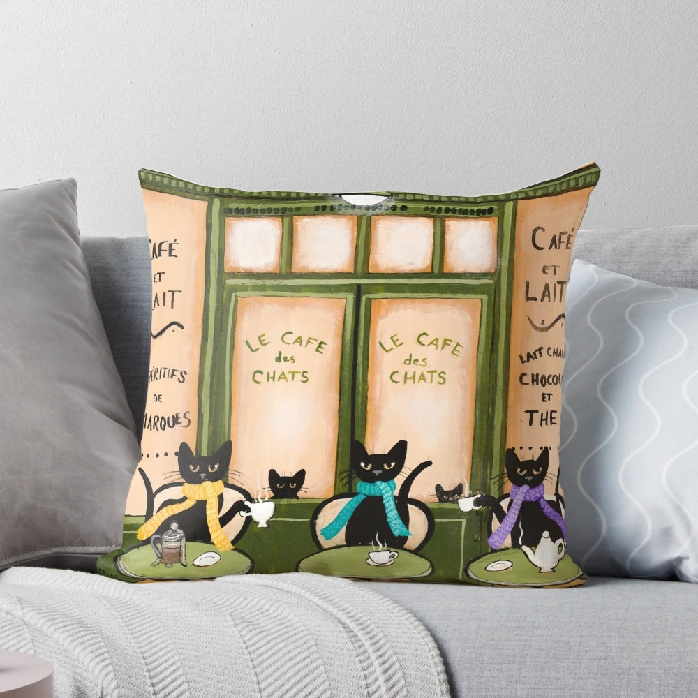 Whimsical black cat pillow featuring a cozy café scene, perfect for cat lovers and coffee enthusiasts.