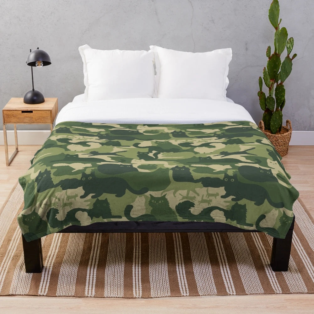 Plush blanket with green camouflage pattern and cat silhouettes