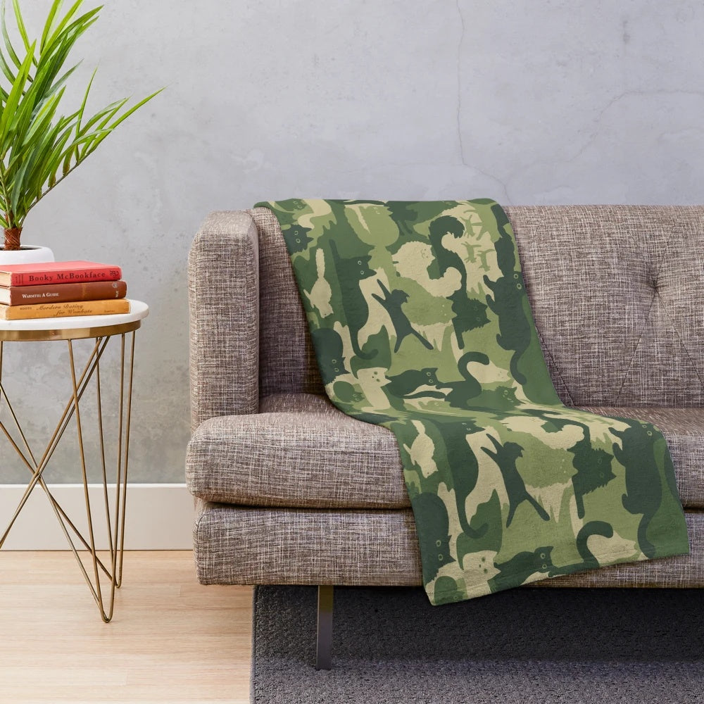 Plush blanket with green camouflage pattern and cat silhouettes