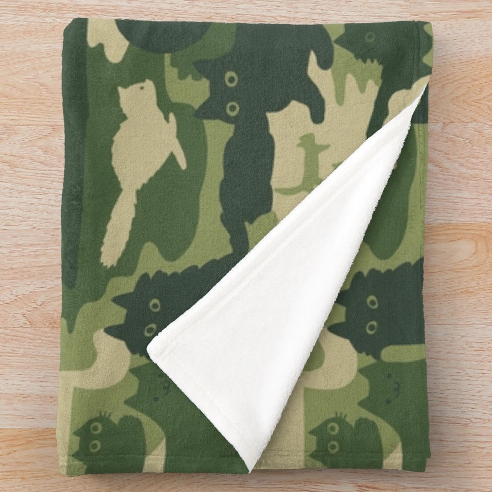 Plush blanket with green camouflage pattern and cat silhouettes