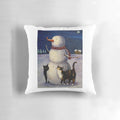 A snow-covered pillow featuring a cute black or tortoiseshell cat in a winter wonderland with a snowman.