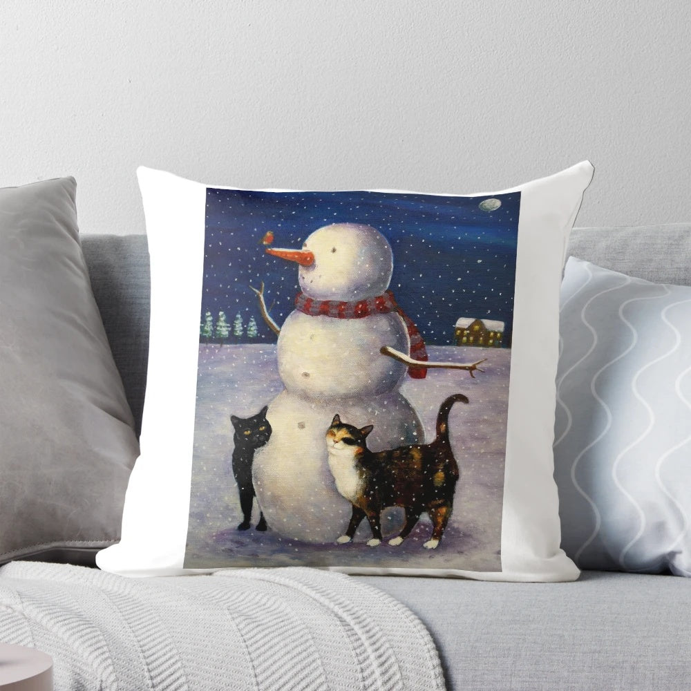 A snow-covered pillow featuring a cute black or tortoiseshell cat in a winter wonderland with a snowman.