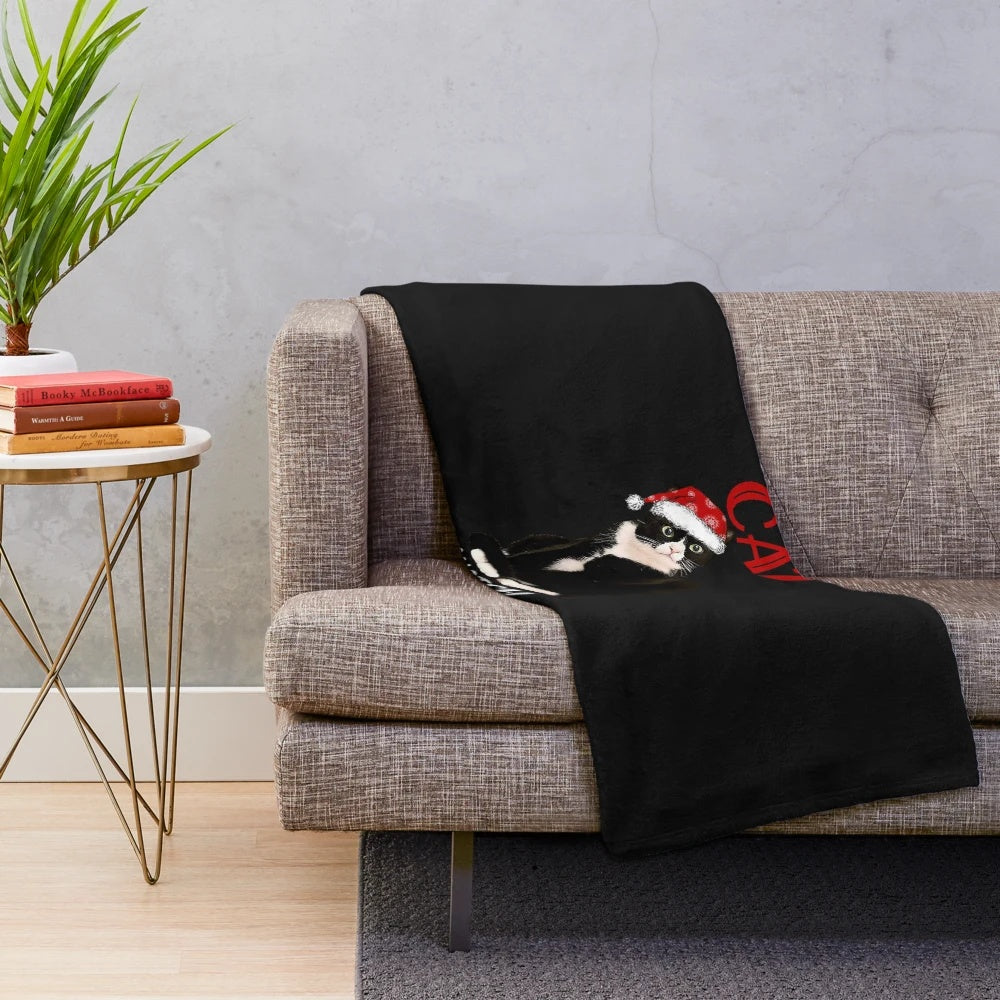 Tuxedo cat enjoying Christmas movies wrapped in a cozy plush blanket