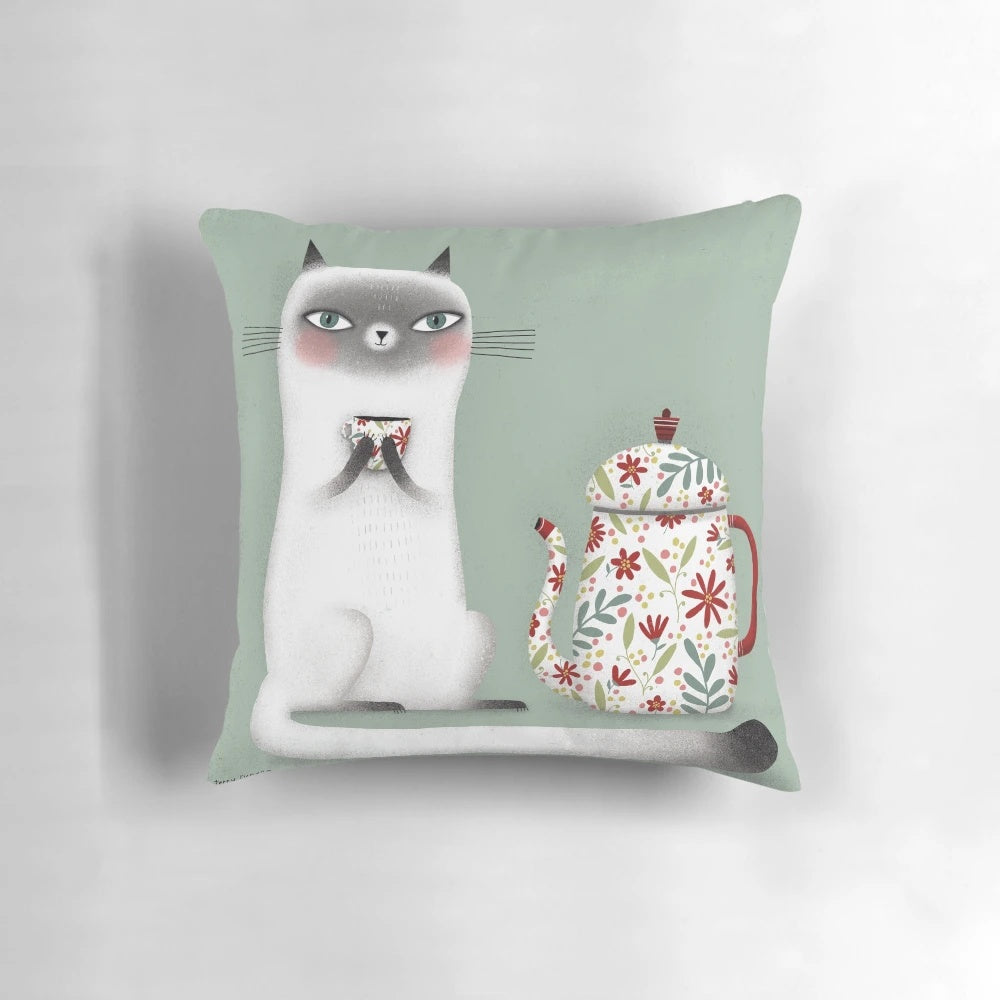 A cozy Siamese cat pillow design featuring a cute cat drinking a hot beverage.
