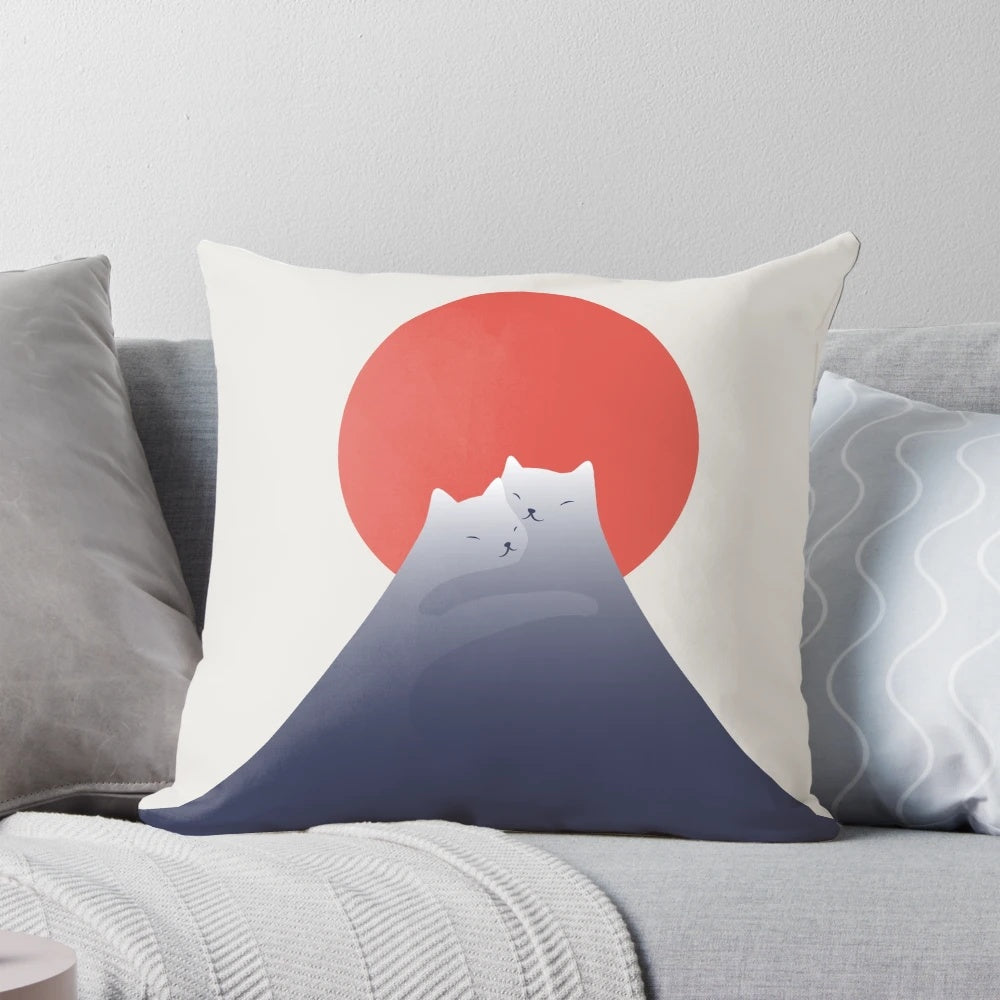 A plush pillow featuring a minimalist illustration of a cat sitting atop a mountain with a beautiful sunset landscape.