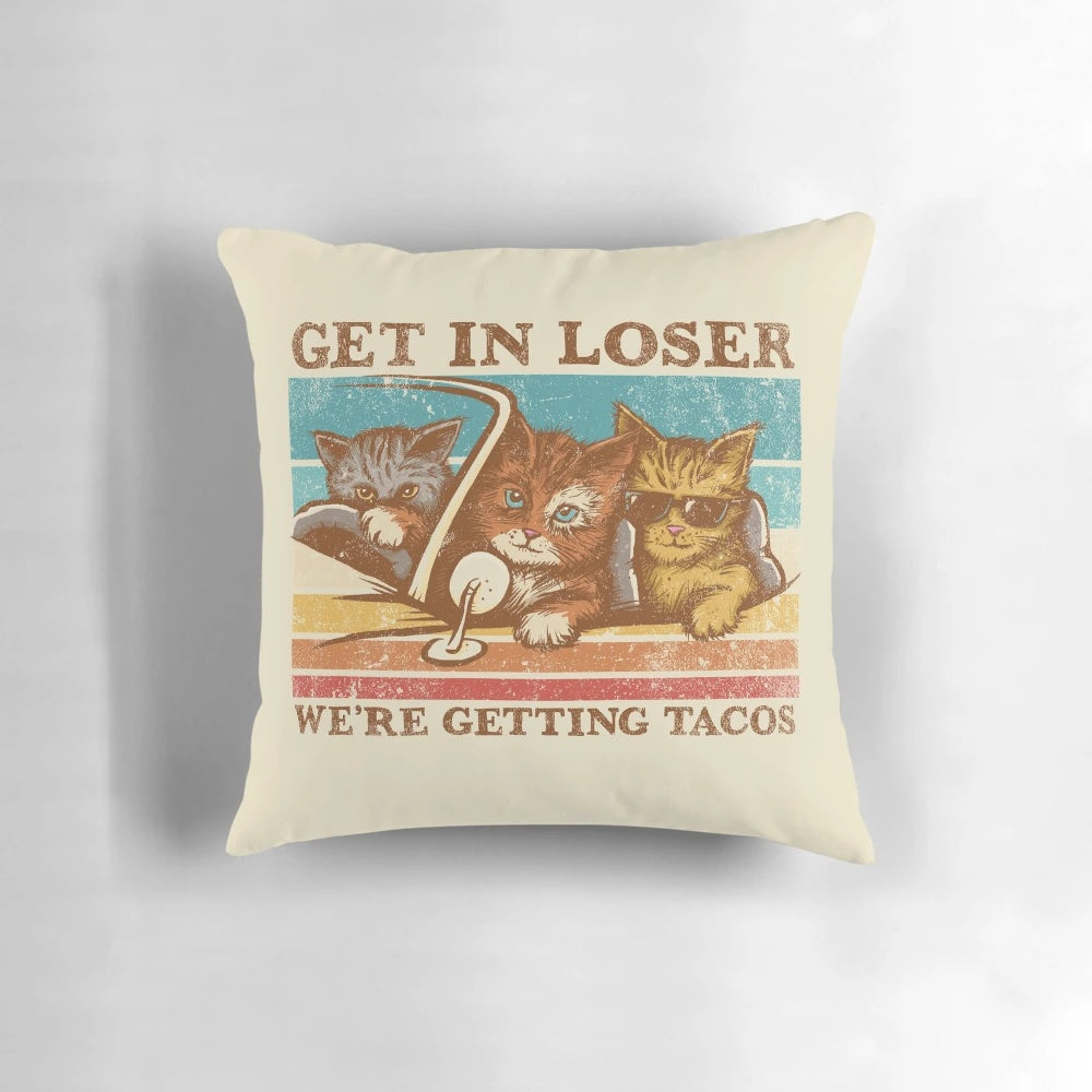 A cozy, vintage-inspired pillow featuring a playful "Get in Loser, We're Getting Tacos" design with cats and tacos.