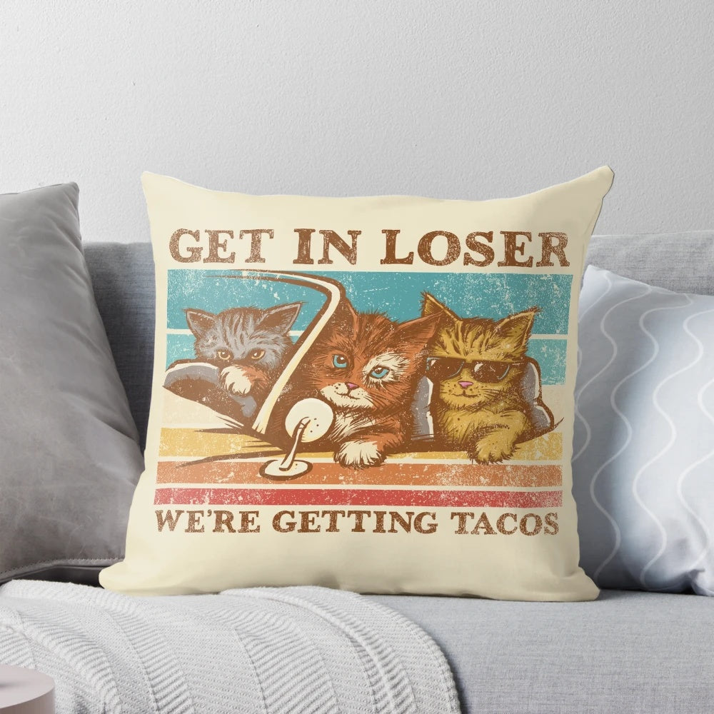 A cozy, vintage-inspired pillow featuring a playful "Get in Loser, We're Getting Tacos" design with cats and tacos.
