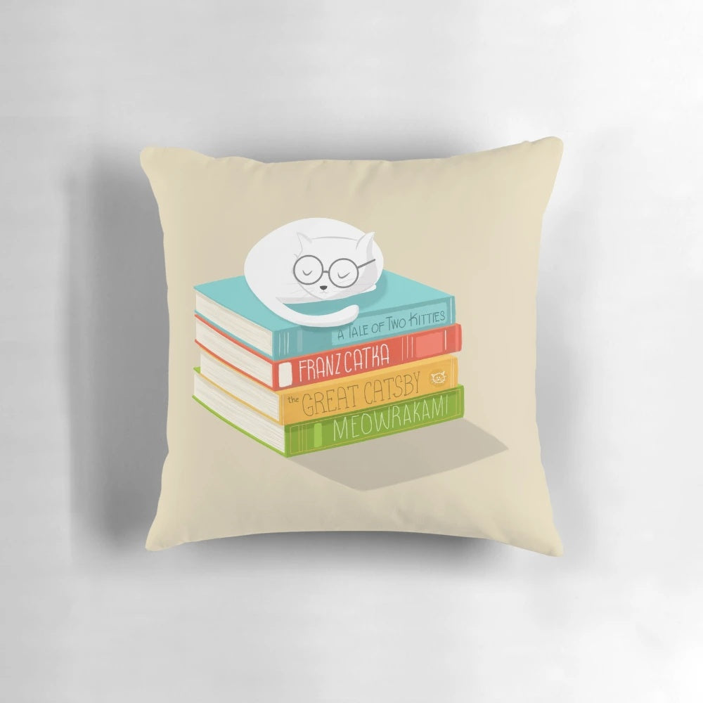 A decorative cat-themed pillow with a whimsical book and literature design.