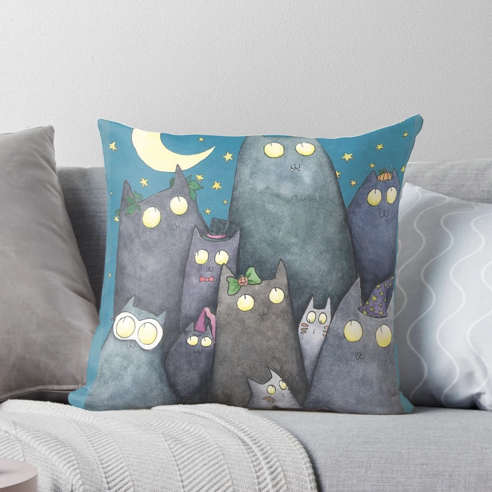 A soft, decorative pillow featuring a colorful design of cats, moons, and stars, perfect for adding a touch of feline fun to your home.