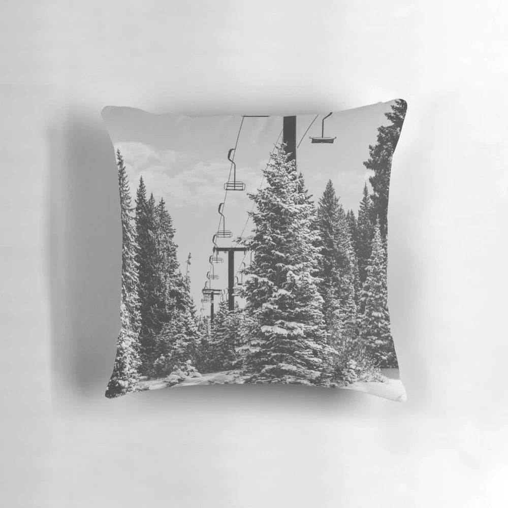 A cozy, decorative pillow featuring a scenic chairlift ascending a snowy mountain landscape.