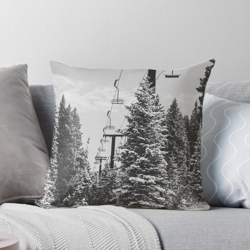 A cozy, decorative pillow featuring a scenic chairlift ascending a snowy mountain landscape.