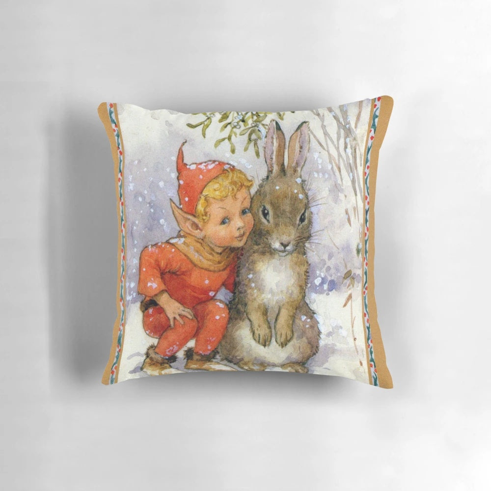 Whimsical Christmas pillow featuring an illustration of an elf and rabbit under mistletoe in a snow-covered woodland scene, designed by artist Margaret Tarrant.