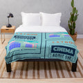 Soft and plush cinema-themed blanket with blue ticket design and pink building backdrop
