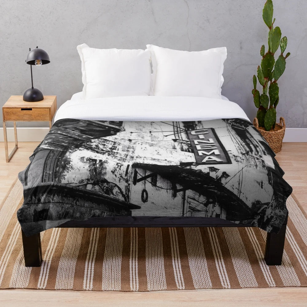 Cozy cinema plush blanket featuring a vintage black and white cityscape with a movie theater