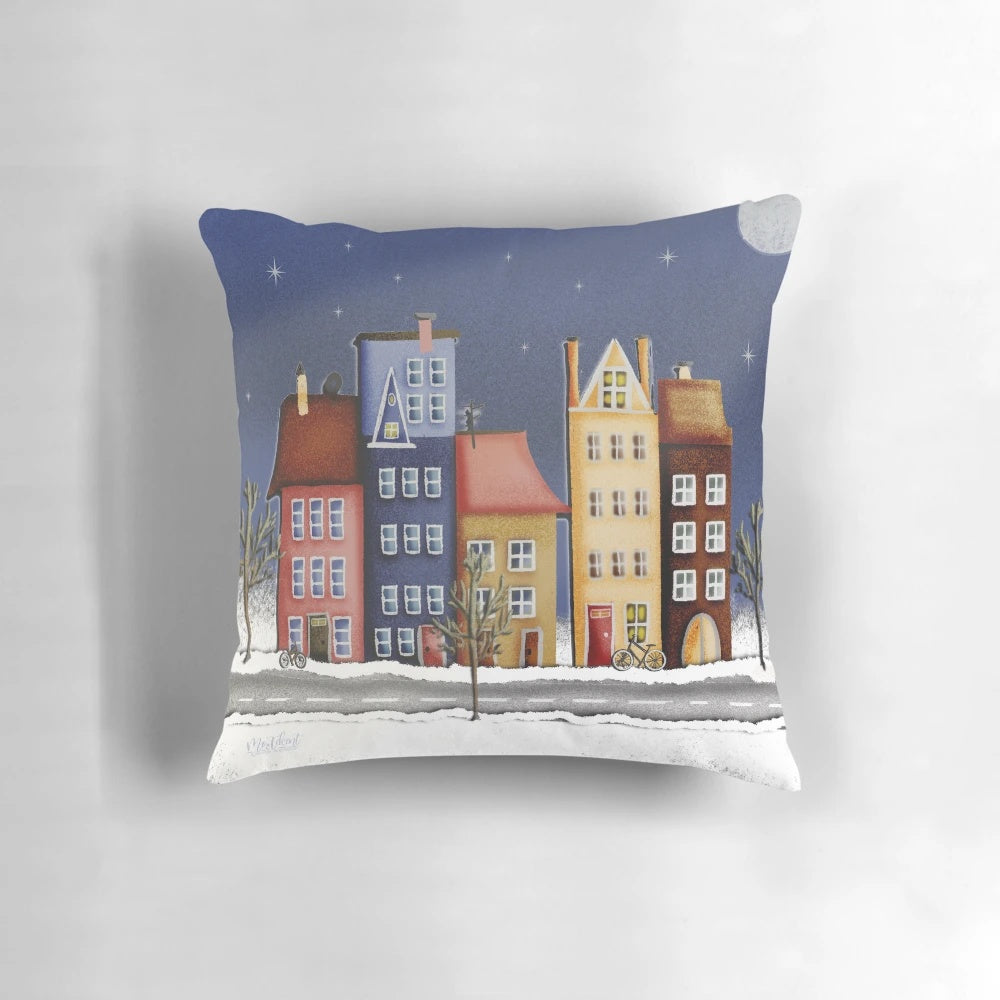 Vibrant pillow with a winter landscape of colorful houses and a starry night sky