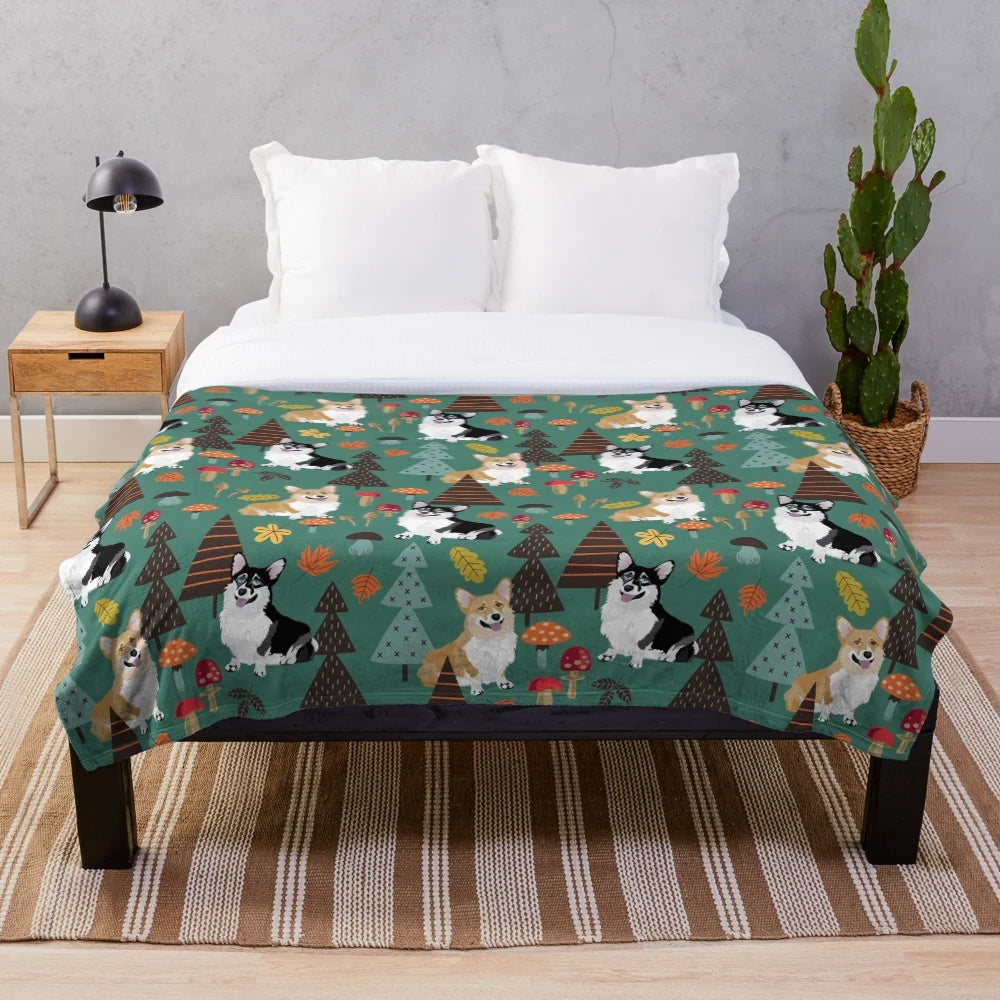 Corgis in a fall forest with mushrooms and flowers, dark teal plush blanket