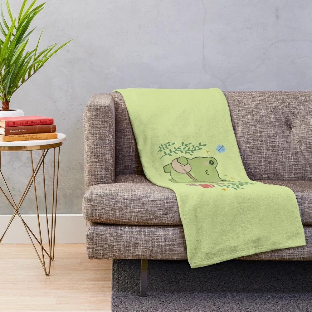 Plush blanket featuring a cute frog playing a banjo with mushrooms and blue butterflies in a cottagecore style