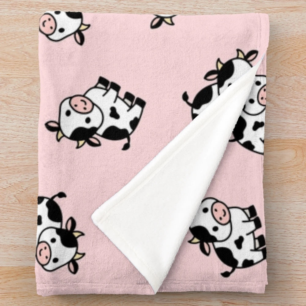 A soft and cuddly cow-themed plush blanket perfect for adding a touch of farmhouse style to any room.