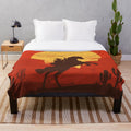 Plush blanket featuring a cowboy silhouette against a sunset landscape