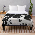 Cowhide plush blanket in a black and white spotted pattern