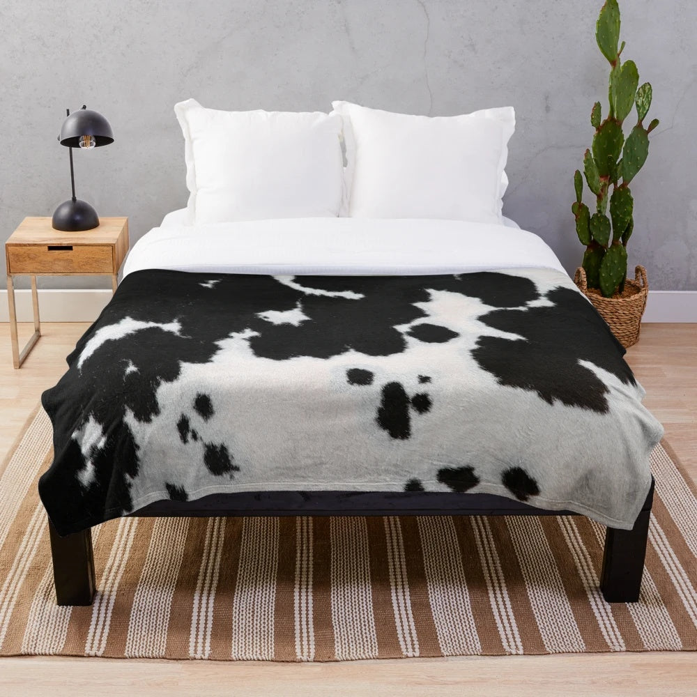 Cowhide plush blanket in a black and white spotted pattern