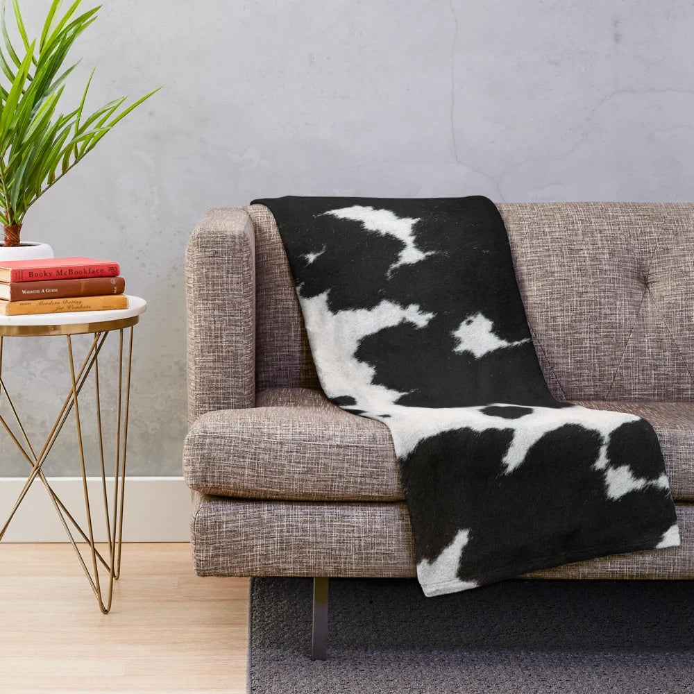 Cowhide plush blanket in a black and white spotted pattern