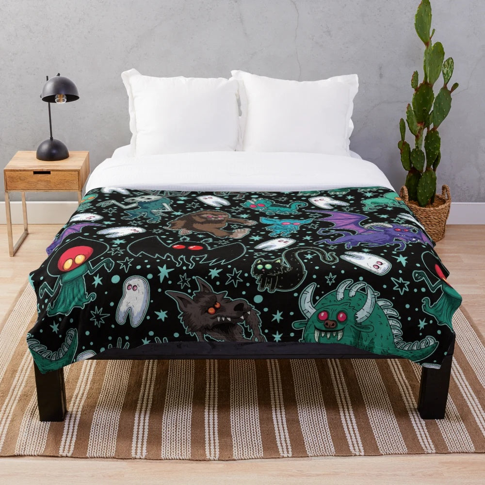 Cozy Cryptid Plush Blanket featuring various cryptid illustrations