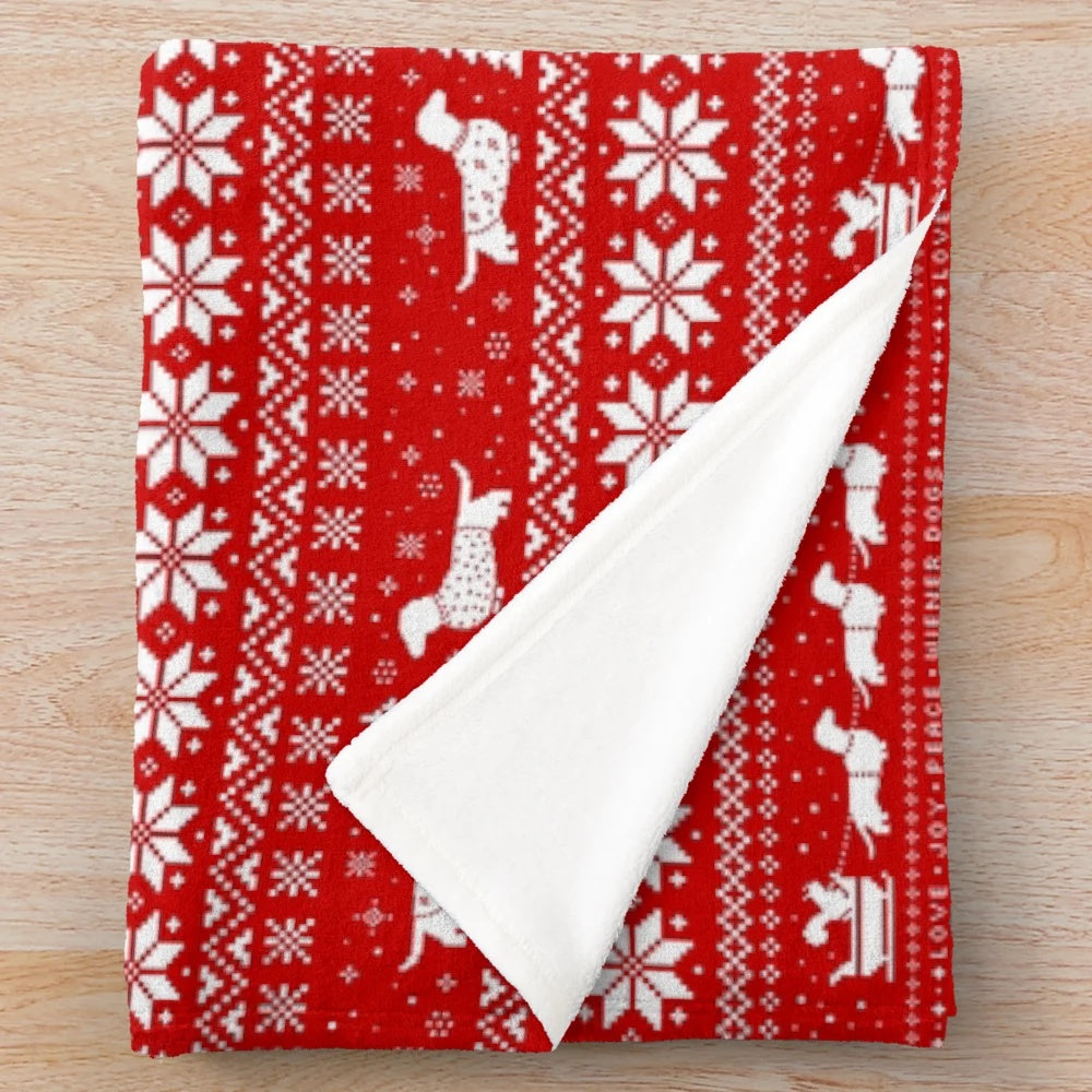 Dachshund dog wearing a Christmas sweater pattern on a plush blanket