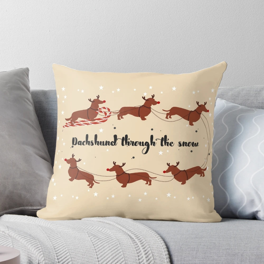 Dachshund Through The Snow Pillow featuring a dachshund dog wearing a Santa hat surrounded by Christmas decorations.