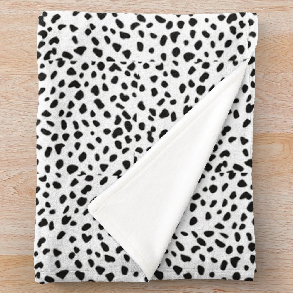 Dalmatian print plush blanket with black and white polka dot pattern