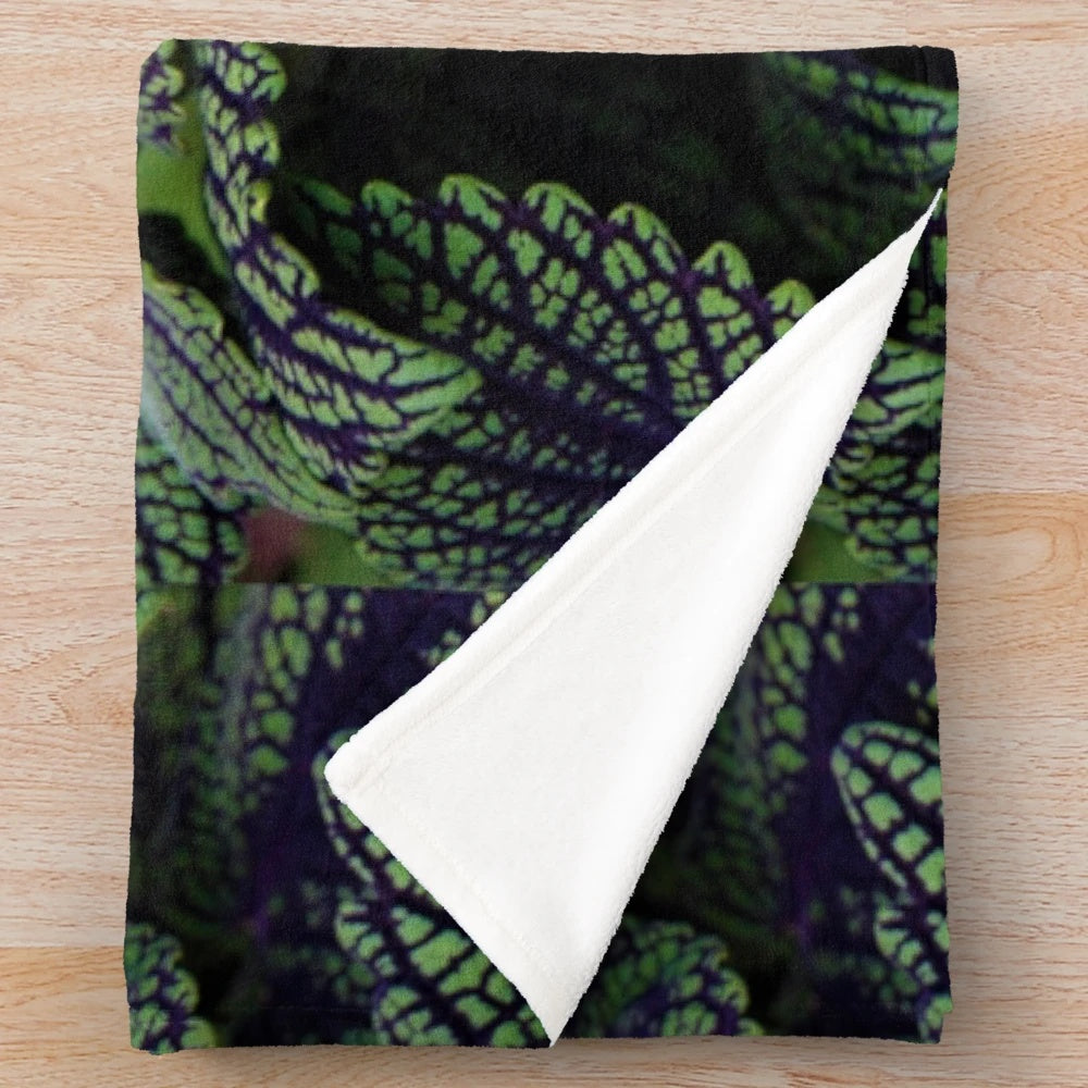 Deep green plush blanket with nature-inspired floral design