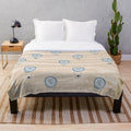 Plush blanket with a seamless pattern of air balloons floating over a desert landscape