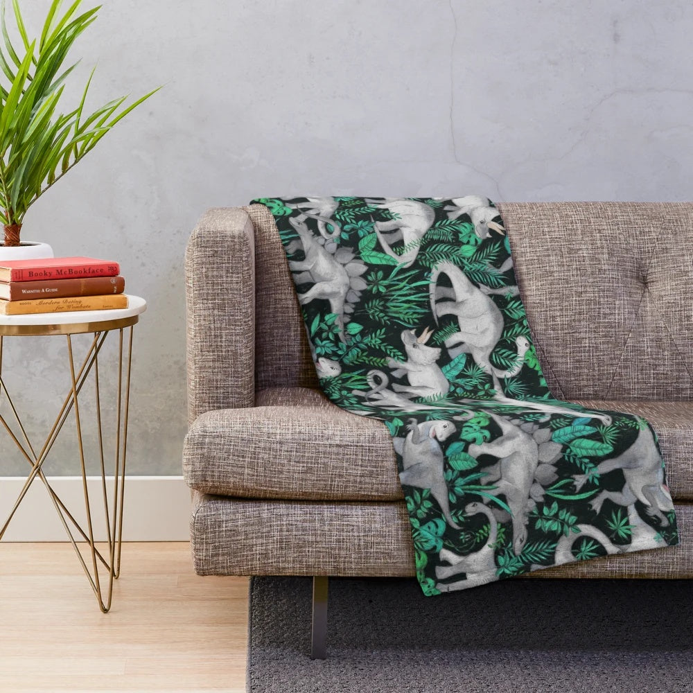 Dinosaur Jungle Plush Blanket with green leaves and dinosaurs